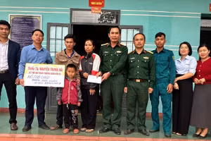 Thiếu tá Quân nhân chuyên nghiệp Nguyễn Trung Hải (thứ 5 từ phải sang), nhân viên Quân lực, Ban Chỉ huy Quân sự xã Ia Rvê cùng lãnh đạo xã Ea Kiết trao tiền các nhà hảo tâm hỗ trợ cháu Dương Quốc Khánh.