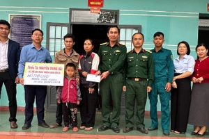 Thiếu tá Quân nhân chuyên nghiệp Nguyễn Trung Hải (thứ 5 từ phải sang), nhân viên Quân lực, Ban Chỉ huy Quân sự xã Ia Rvê cùng lãnh đạo xã Ea Kiết trao tiền các nhà hảo tâm hỗ trợ cháu Dương Quốc Khánh.