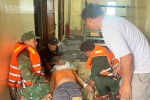 Cán bộ, chiến sĩ Đồn Biên phòng Cửa khẩu Cảng Vũng Rô khẩn trương sơ cứu thuyền viên bị chấn thương ngay tại khoang tàu.