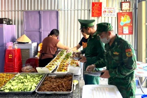 Cán bộ, chiến sĩ Đồn Biên phòng Xuân Đài cùng các tình nguyện viên chuẩn bị, chế biến các suất ăn trong mô hình “Bếp ăn 0 đồng”.