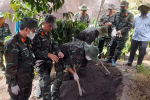 Các lực lượng chức năng tiến hành khai quật tìm hài cốt liệt sĩ. (Ảnh: Quốc Khánh)