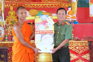 Đại tá Phạm Minh Lũy, Phó Giám đốc Công an tỉnh Cà Mau (bìa phải) trao tặng quà Tết tại chùa Cao Dân, xã Tân Lộc, tỉnh Cà Mau.