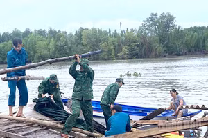 Cán bộ, chiến sĩ Đồn Biên phòng Đất Mũi cùng các lực lượng có liên quan tại địa phương giúp dân khắc phục hậu quả vì sạt lở đất.