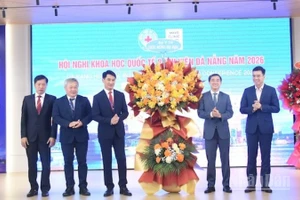 Thứ trưởng Y tế Trần Văn Thuấn tặng hoa chúc mừng Ban giám đốc Bệnh viện Đà Nẵng tổ chức thành công hội nghị. (Ảnh: ANH ĐÀO)