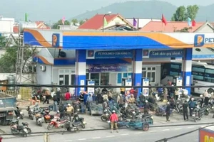 Cảnh người dân kéo xe ba gác với nhiều can nhựa đến mua xăng dầu tại cửa hàng ở khu vực Roòn, xã Phú Trạch sáng nay.