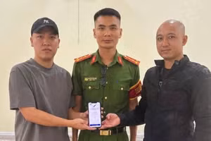 Anh Hoàng Quốc Cường (bên trái) trả lại 5 tỷ đồng chuyển khoản nhầm cho anh Quân trước sự chứng kiến của đại diện Công an xã Hoàn Lão. (Ảnh: Công an xã Hoàn Lão)