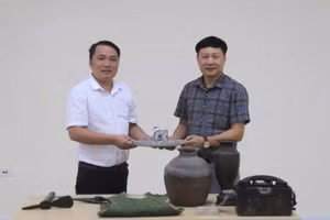 Phó Giám đốc Bảo tàng tỉnh Quảng Trị Mai Thế Trung (áo trắng) trao hiện vật, tư liệu phục vụ xây dựng Bảo tàng Đảng Cộng sản Việt Nam 