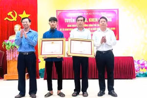 Bố con ông Cao Hữu Tình và em Cao Hoàng Ân Đức nhận Bằng khen của Thủ tướng Chính phủ vì đã có hành động dũng cảm cứu người đuối nước trên sông Gianh.