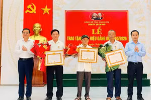 Thường trực Đảng ủy xã Kim Phú, tỉnh Quảng Trị trao Huy hiệu Đảng và tặng hoa chúc mừng các đảng viên.