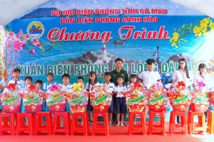 Đại tá Phạm Minh Giang, Chính ủy Bộ đội Biên phòng Cà Mau (đứng giữa) trao quà tặng học sinh nghèo vùng ven biển Gành Hào.