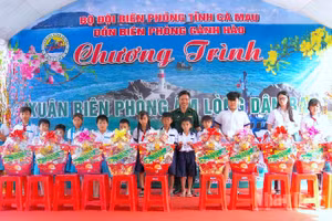 Đại tá Phạm Minh Giang, Chính ủy Bộ đội Biên phòng Cà Mau (đứng giữa) trao quà tặng học sinh nghèo vùng ven biển Gành Hào.