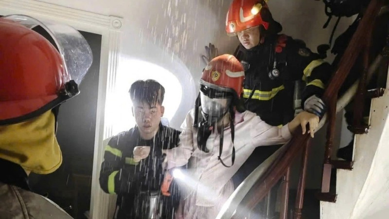 Giải cứu 1 người bị mắc kẹt trong đám cháy. (Ảnh: Công an Hà Nội)