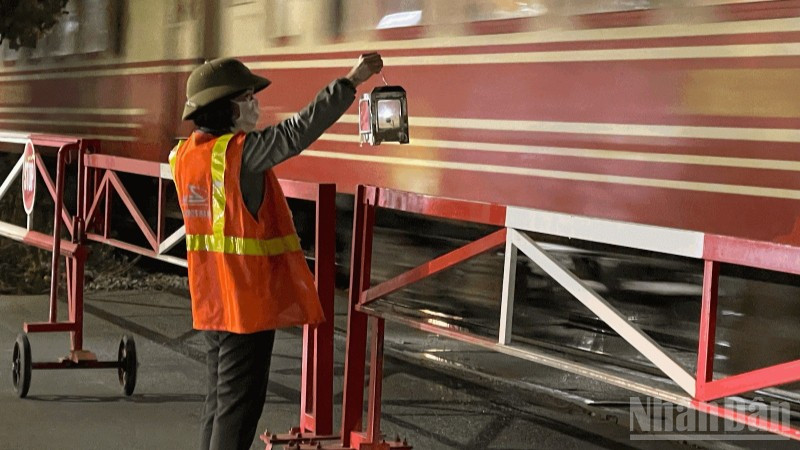 Nữ nhân viên đường sắt ngày ngày vẫn lặng lẽ bên thanh gác chắn bảo đảm an toàn cho mỗi chuyến tàu.