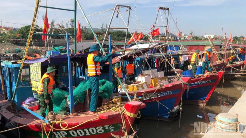 Cán bộ, chiến sĩ Đồn Biên phòng Đồ Sơn hỗ trợ ngư dân chằng buộc phương tiện tại khu vực neo đậu.