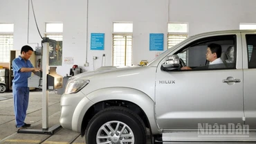 Đăng kiểm viên thực hiện đăng kiểm với một xe ô-tô.