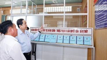 Chủ tịch Quốc hội Trần Thanh Mẫn trao đổi với cán bộ của Trung tâm phục vụ hành chính công xã Vị Thủy. (Ảnh: TTXVN)
