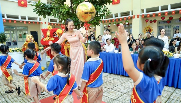 Cô Nguyễn Thị Kim Trang, Hiệu trưởng Trường tiểu học Phạm Văn Chính chào đón các em học sinh lớp 1 trong ngày khai giảng năm học mới. tieu-hoc-1.jpg