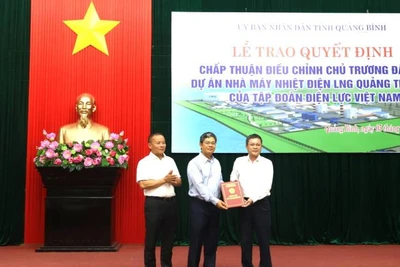 Phó Chủ tịch tỉnh Quảng Bình Phan Phong Phú (bên phải) trao quyết định chấp thuận điều chỉnh chủ trương đầu tư dự án Nhà máy nhiệt điện LNG Quảng Trạch II cho đại diện lãnh đạo Tập đoàn Điện lực Việt Nam.