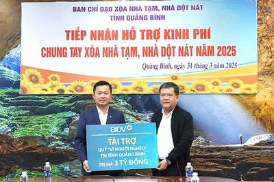 Chủ tịch Ủy ban nhân dân tỉnh Quảng Bình Trần Phong (bên phải) tiếp nhận hỗ trợ của BIDV để xóa nhà tạm, nhà dột nát cho hộ nghèo