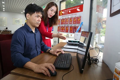 Cán bộ bộ phận một cửa Ủy ban nhân dân quận Tây Hồ hướng dẫn người dân làm thủ tục hành chính.