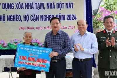 Chủ tịch Ủy ban nhân dân tỉnh Thái Bình Nguyễn Khắc Thận trao biểu trưng hỗ trợ 100 triệu đồng xây nhà mới cho bà Nguyễn Thị Xíu, là hộ nghèo tại xã Tự Tân, huyện Vũ Thư.