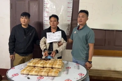 Đối tượng Tao Mùa (ở giữa) cùng tang vật 20 bánh (chứa 120 nghìn viên ma túy tổng hợp) khi bị lực lượng chức năng bắt giữ. (Ảnh: Công an Điện Biên)