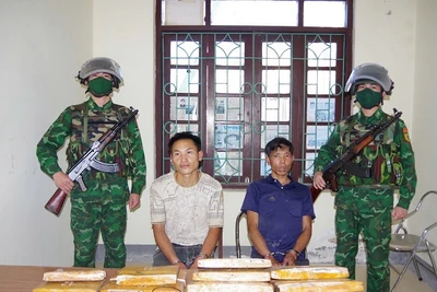 Hai đối tượng gồm: Mùa A Nhà, Mùa A Pha cùng tang vật khi bị bắt. (Ảnh: ANH DŨNG)