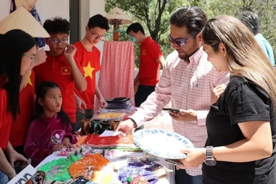 Khách hàng tham quan gian trưng bày các sản phẩm thủ công mỹ nghệ tại sự kiện. (Ảnh: TTXVN)