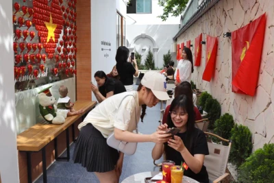 Du khách hào hứng "check-in" tại quán cà-phê ở Hà Nội. (Ảnh: nhandan.vn)