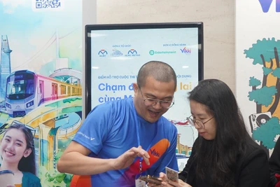 Nhân viên Ngân hàng hỗ trợ hành khách làm thẻ đi Metro số 1 miễn phí tại các nhà ga trên hành trình. (Ảnh: Thế Anh) 