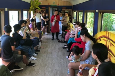 Biểu diễn văn nghệ phục vụ hành khách trên toa cộng đồng.