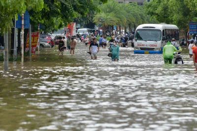 Sáng 24/7, nước ngập sâu khiến các phương tiện không thể đi qua, người dân buộc phải lội nước di chuyển ra ngoài.