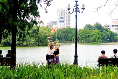 Du khách nước ngoài chụp ảnh tại Hồ Gươm, Hà Nội (Ảnh: T.LINH)