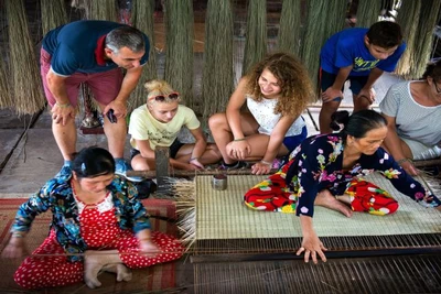 Du khách quốc tế trải nghiệm nghề làm chiếu thủ công. (Ảnh: Vietnamtravel)