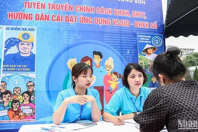 Cán bộ Bảo hiểm xã hội quận Long Biên, Hà Nội giới thiệu chính sách với người lao động. (Ảnh: NGÂN ANH)