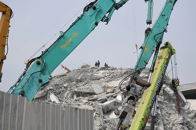 Nỗ lực tìm kiếm nạn nhân trên đỉnh đống đổ nát. (Ảnh: XUÂN SƠN)