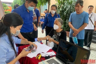 Nhân viên Trung tâm Quản lý Giao thông công cộng Thành phố Hồ Chí Minh hướng dẫn người dân sử dụng thẻ đi xe buýt miễn phí.