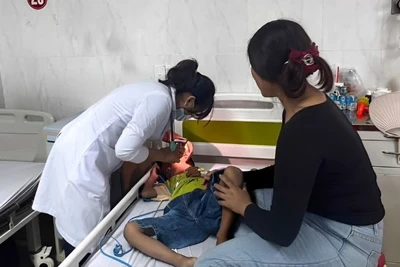 Bác sĩ khoa Nhi tổng hợp, Bệnh viện đa khoa vùng Tây Nguyên thăm khám cho bệnh nhi hóc dị vật đường thở. Ảnh: Quang Nhật.