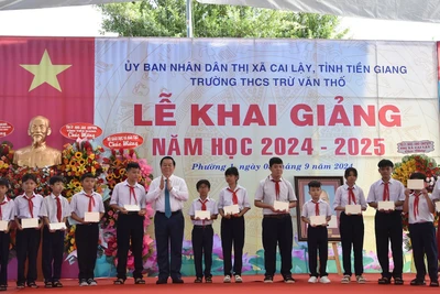 Trưởng Ban Tuyên giáo Trung ương Nguyễn Trọng Nghĩa tặng học bổng cho các em học sinh nghèo nhân dịp lễ khai giảng. 