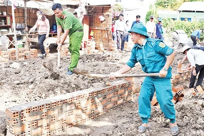 Lực lượng vũ trang cùng các đoàn thể chính trị xã Huyền Hội, huyện Càng Long, tỉnh Trà Vinh, hỗ trợ người dân xây nhà. (Ảnh: KHỞI - GIANG)
