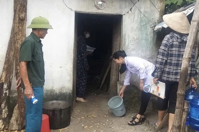 Cán bộ y tế hướng dẫn người dân vệ sinh môi trường sau bão, lụt trên địa bàn huyện Ứng Hòa, Hà Nội.