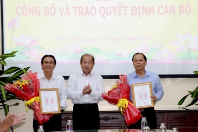 Phó Chủ tịch Ủy ban nhân dân tỉnh Đồng Tháp Đoàn Tấn Bửu trao quyết định cho ông Trần Tấn Lực (bìa phải) và ông Nguyễn Duy Trung. (Ảnh: NGUYỆT ÁNH) 