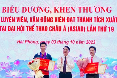Lãnh đạo Ủy ban nhân dân thành phố Hải Phòng trao Bằng khen và tiền thưởng tặng vận động viên Phạm Quang Huy (trái) và huấn luyện viên Phạm Cao Sơn (phải).