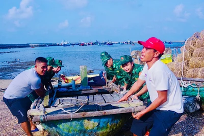 Cán bộ, chiến sĩ Đồn Biên phòng Bạch Long Vĩ giúp ngư dân đưa các phương tiện nhỏ lên bờ tránh trú bão số 3. (Ảnh: SƠN HÀ, Bộ đội Biên phòng Hải Phòng)