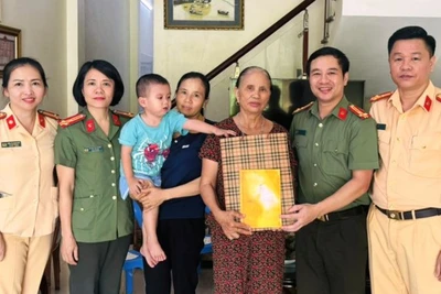 Đại diện đoàn công tác trao tặng quà cho trẻ em cùng gia đình.