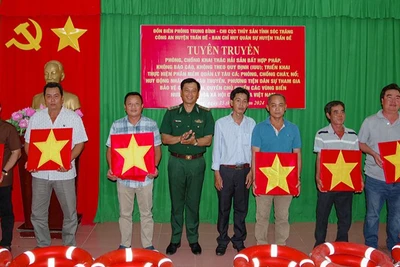 Tặng cờ Tổ quốc và phao cứu sinh cho ngư dân.