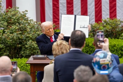 Tổng thống Mỹ Donald Trump giơ cao sắc lệnh hành pháp về thuế quan đối ứng tại Vườn Hồng của Nhà Trắng ở Washington D.C. ngày 2/4/2025. (Ảnh: Tân Hoa xã)