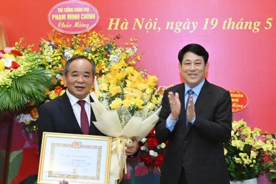 Chủ tịch nước Lương Cường trao Huy hiệu 40 năm tuổi Đảng, tặng hoa chúc mừng Chủ nhiệm Văn phòng Chủ tịch nước Lê Khánh Hải.