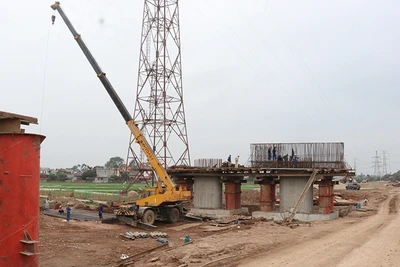 Công nhân thi công phần trụ cột cầu Kênh Vàng. (Ảnh TTXVN)
