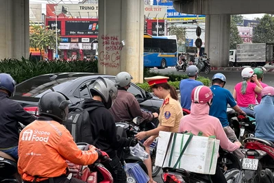 Nữ cảnh sát giao thông Công an tỉnh Đồng Nai phát nước suối cho người dân về quê đón Tết. 